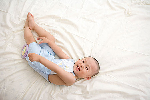 躺在床上玩耍的嬰兒