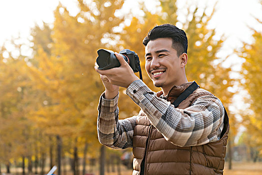 年轻男子秋游拍照