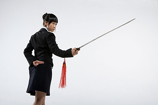 一位穿着职业套裙的女士在练剑