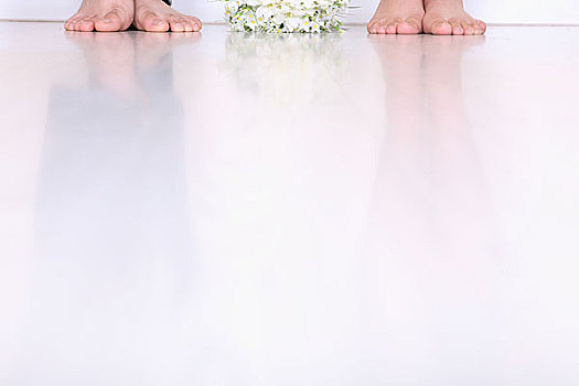 两双脚旁放着一束鲜花