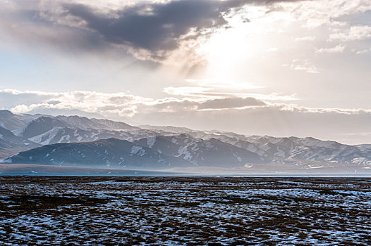 中国新疆巴音布鲁克夕阳下的草原雪山背景高山风光