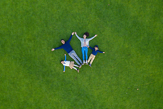 年轻家庭躺在草地上