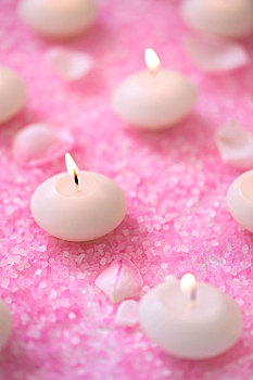 放在桌子上的粉色浴盐和蜡烛