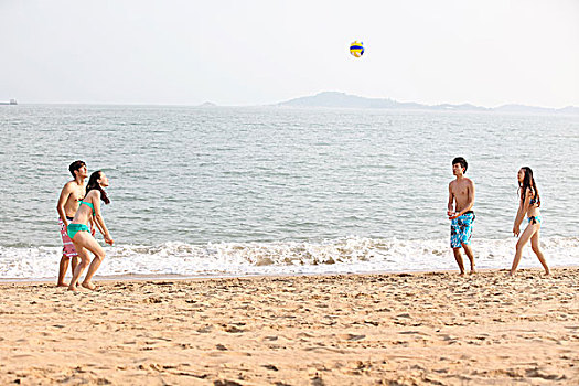 時尚青年人海邊沙灘排球