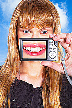 肖像,年轻,女人,拿着,数码相机,嘴,显示屏
