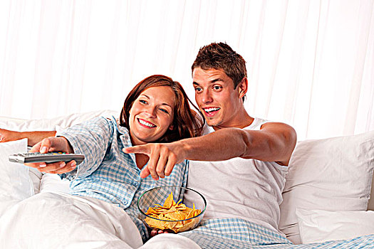 男青年,女人,躺下,白色,床,看电视,吃,松脆食品