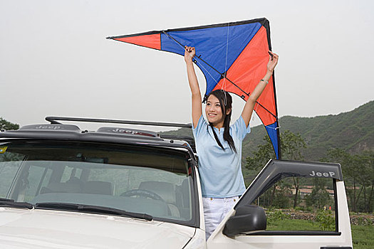 一对年轻的女孩开着越野车在郊外放风筝