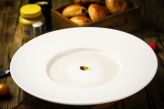 木桌子上的一份泡沫丰富的奶油蘑菇汤