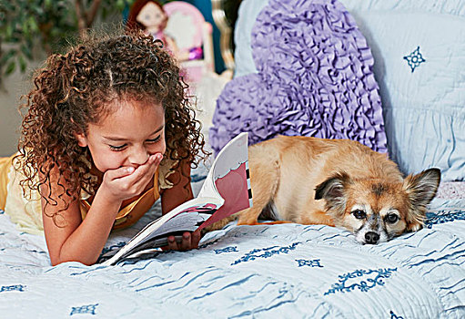 女孩,狗,躺着,床,读,书本,手摸嘴,笑