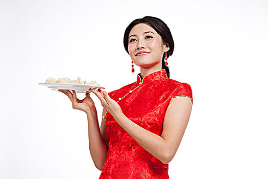 棚拍身穿中国传统服装的年轻女人端饺子