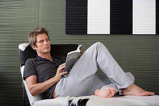 一个男人在沙发上看书