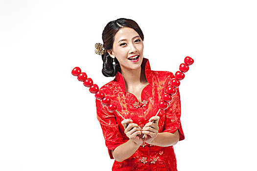 棚拍身穿中国传统服装的年轻女人和糖葫芦
