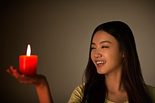 年轻女性拿着红蜡烛