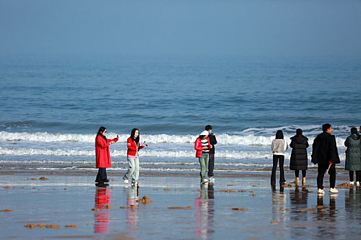 蔚蓝大海让人心旷神怡,游客漫步沙滩放飞心情