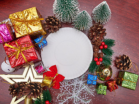 木纹桌面上被各种圣诞装饰品包围的白色底座