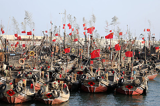 山东省日照市,数百艘渔船停泊港湾,悬挂国旗插摇钱树期盼来年鱼虾满仓