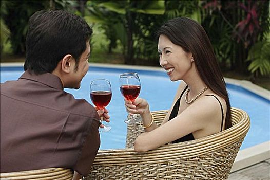 坐,夫妇,游泳池,拿着,葡萄酒杯