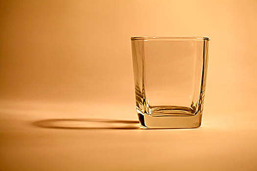 暖光下透明的方口玻璃杯和它的倒影