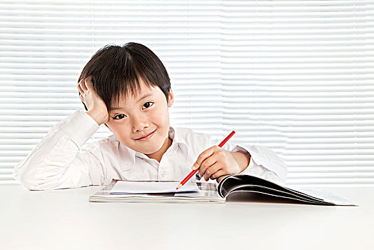 穿白襯衫坐在椅子上的小學生