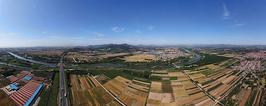 山东省日照市,绿水环绕万亩麦田,蓝天白云映衬下的金色土地让人喜不自禁