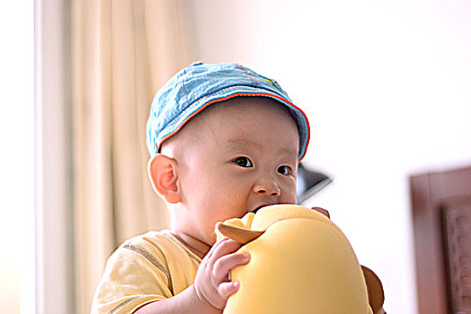 一名8个月的女婴抱着玩具在玩