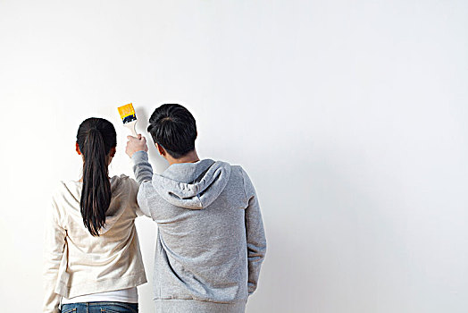 年轻情侣快乐粉刷墙壁