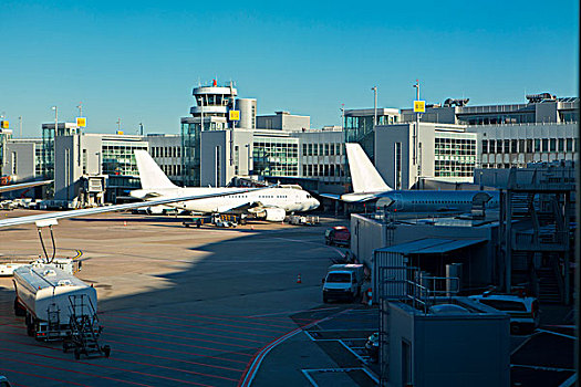 国外渡假旅行,多台飞机在停机坪上,还有多部工程车