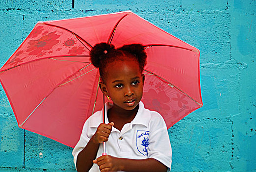 dominica,roseau,preschool,ccf,young,girl,playing,with,pink,umbrella,against,blue,wall