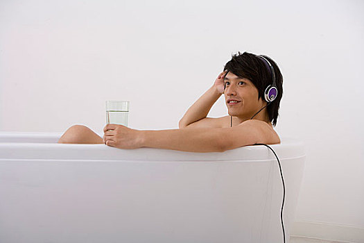 一个男人边听音乐边泡澡