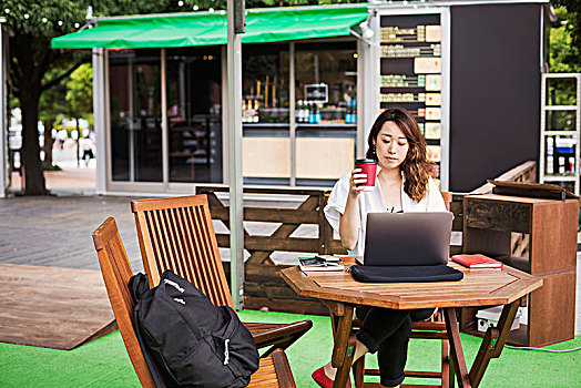 女人,黑发,穿,白衬衫,坐,正面,笔记本电脑,桌子,街头咖啡馆,工作