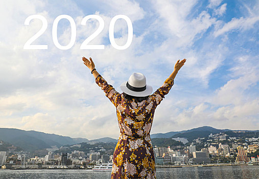 2020数字和站在海边张开双臂伸向天空的女人合成图像