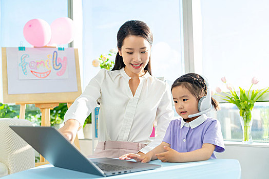 老师和小女孩一起使用电脑