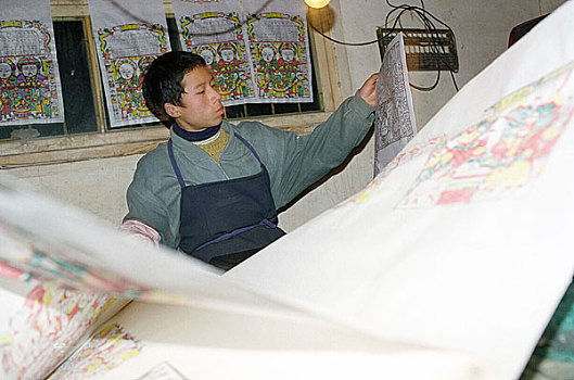 河南开封朱仙镇年画艺人张廷旭的儿子在印制年画