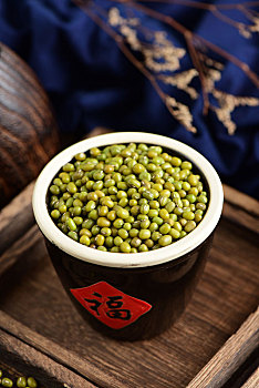复古中国风格背景上放在福字水缸里的绿豆特写图片