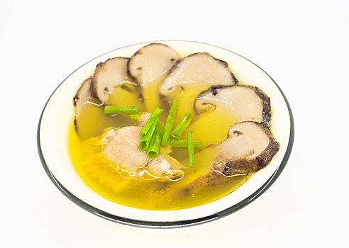 白色背景瓷碗里乘的松茸炖鸡汤