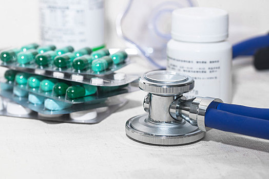 听诊器在桌上,虚化的胶囊,药品,药瓶与医疗用品