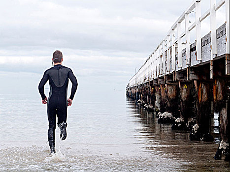 后视图,男人,紧身潜水衣,跑,海洋,码头,墨尔本,维多利亚,澳大利亚,大洋洲