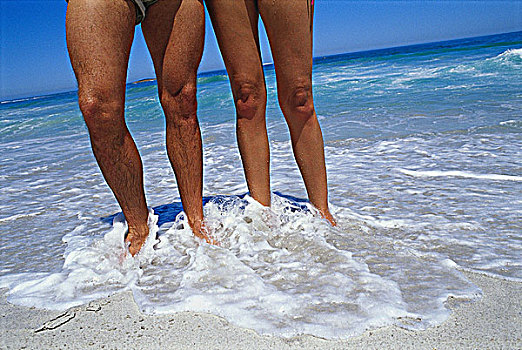 低视角,伴侣,站在水中,海滩