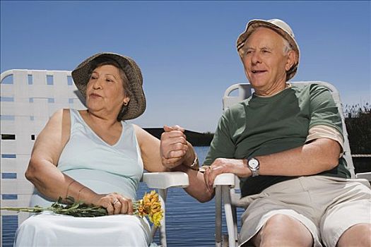 老年,夫妻,坐,湖岸,握手