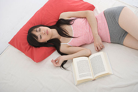 睡觉的女人身边摆着一本未看完的书