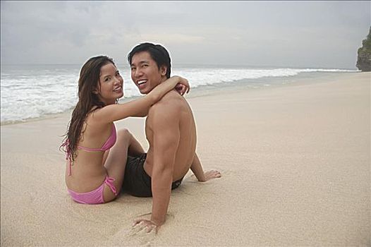 坐,夫妇,海滩,搂抱,看镜头
