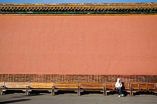 北京故宫宫墙下休息的游人