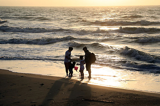 山东省日照市,清晨的海边环境宜人,游客漫步沙滩赶海拾贝