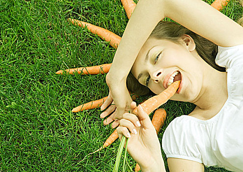 女人,躺着,草,吃,胡萝卜,放置,头部,看镜头,微笑
