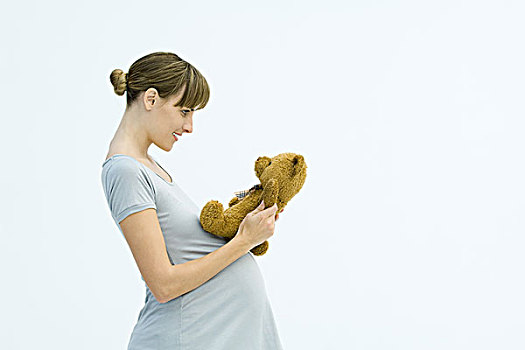 孕妇,拿着,泰迪熊,微笑,侧面视角
