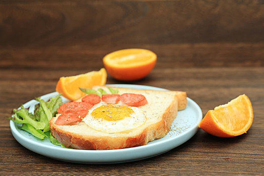 美味好吃的健康早餐切片面包煎蛋火腿和橙子