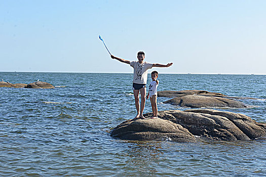 海边父子玩水捡贝壳玩水的快乐少年