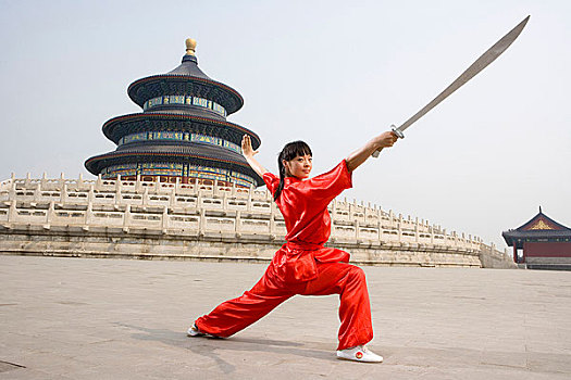 中国武术--一名女武术运动员在天坛祈年殿前练刀法