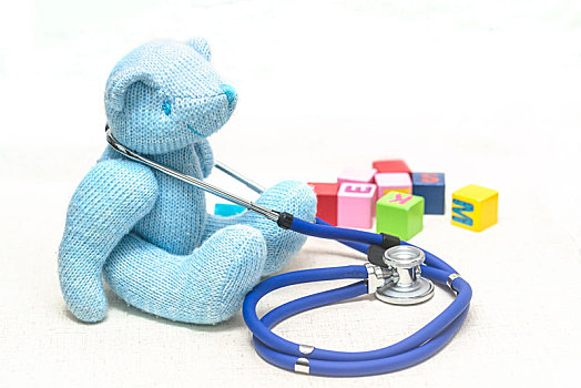 地板上泰迪熊毛绒玩具,听诊器与积木,寓意儿童健康,医疗保健概创意图