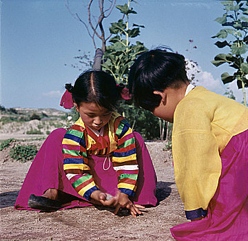 两个,年轻,韩国,女孩,浅色,传统服装,蹲,地上,玩,游戏,小,石头